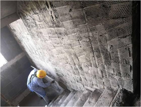 工人对墙面基层进行拍浆法施工